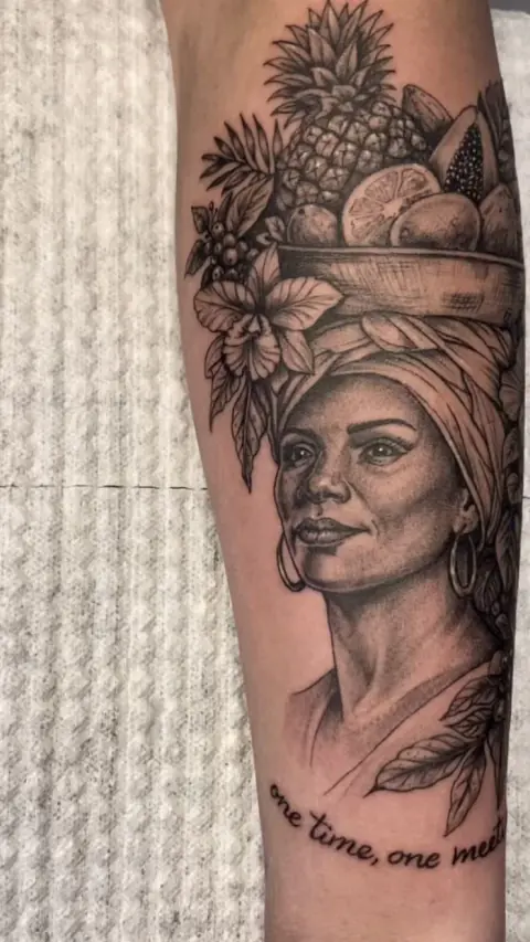 Tatuaje de una palenquera con frutas en el antebrazo